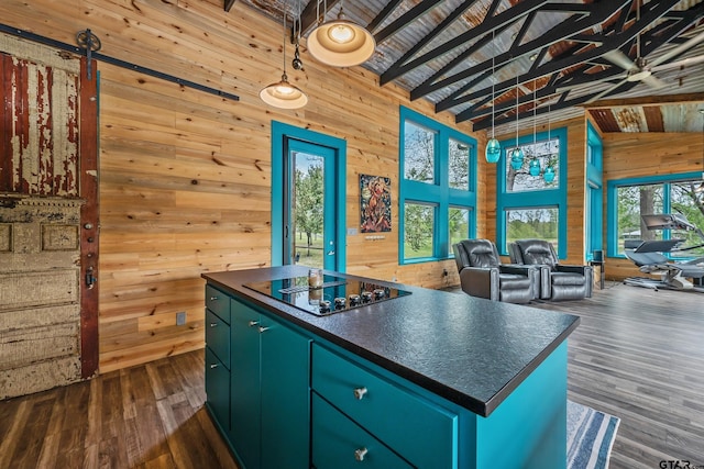 kitchen with wood walls, green cabinetry, dark countertops, and black electric stovetop