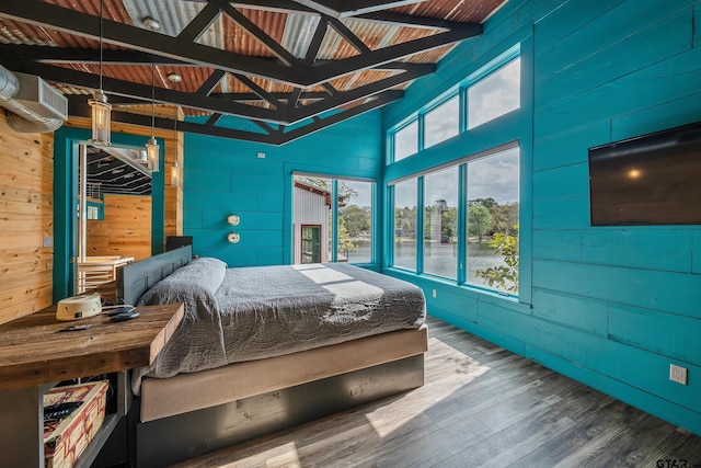 bedroom featuring wood finished floors, wooden walls, a wall unit AC, and beam ceiling