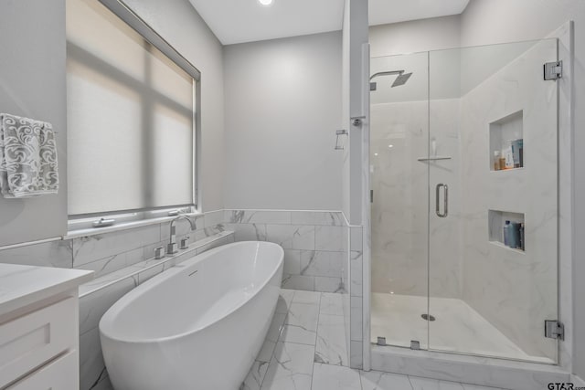 14611 Twin Pines Ln, Lindale, TX 75771 - bathroom with tile walls, marble look tile flooring, a marble finish shower, a soaking tub, and vanity