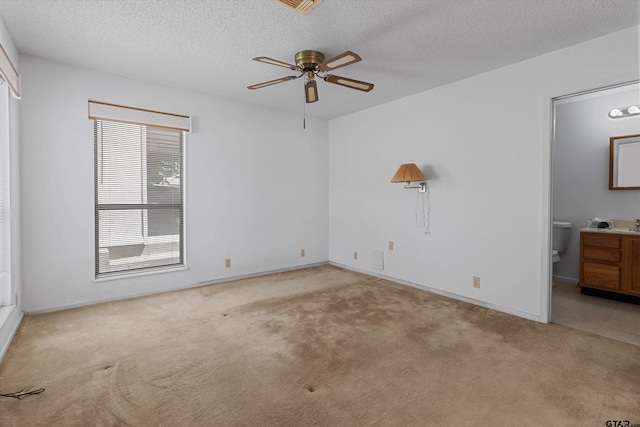 spare room with light carpet and a textured ceiling