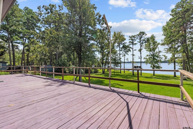 wooden terrace with a yard and a water view