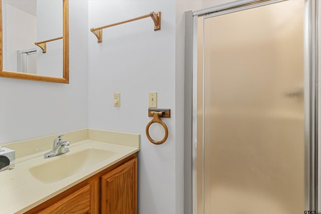 bathroom with a shower with door and vanity