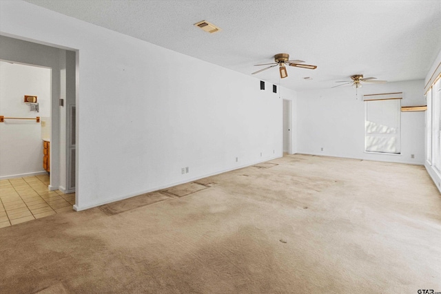 unfurnished living room featuring light colored carpet and a textured ceiling