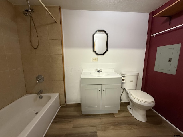 full bath with toilet, electric panel, washtub / shower combination, and wood finished floors