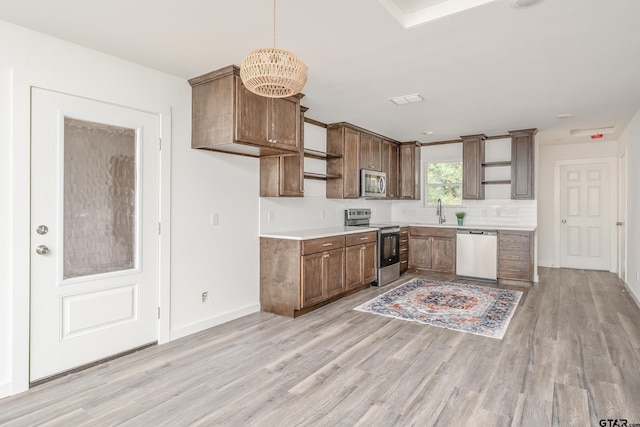 kitchen with light hardwood / wood-style flooring, a chandelier, decorative light fixtures, and appliances with stainless steel finishes