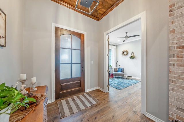 foyer entrance featuring baseboards, ornamental molding, and wood finished floors