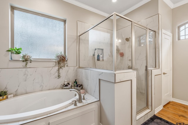 bathroom with a garden tub, a shower stall, ornamental molding, and wood finished floors