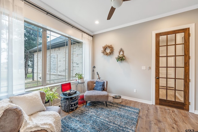 living area with recessed lighting, ornamental molding, ceiling fan, wood finished floors, and baseboards
