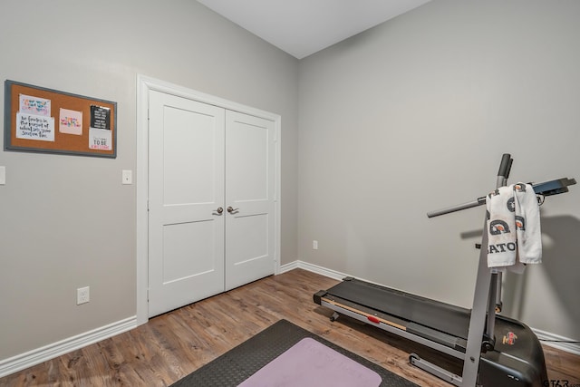 workout room with baseboards and wood finished floors