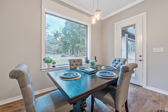 dining room with crown molding, baseboards, and wood finished floors