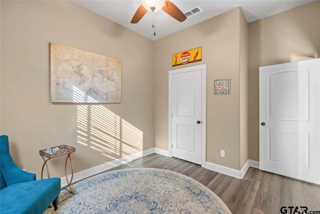 sitting room with ceiling fan and hardwood / wood-style flooring