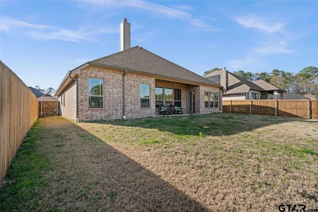 back of house with a lawn