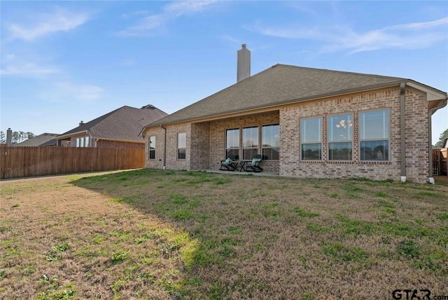 rear view of property featuring a yard