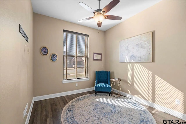 living area featuring dark hardwood / wood-style floors and ceiling fan