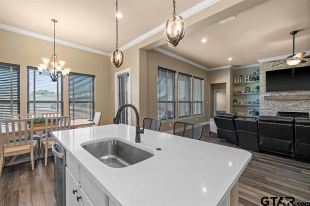 kitchen featuring sink, dark wood-type flooring, decorative light fixtures, a kitchen island with sink, and ceiling fan with notable chandelier