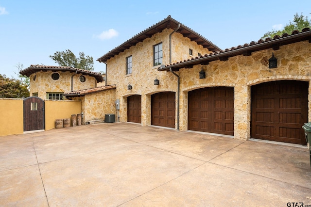 view of front of property with central AC unit and a garage