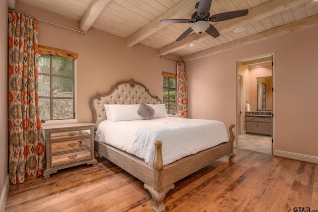 bedroom featuring multiple windows, ceiling fan, ensuite bathroom, and hardwood / wood-style flooring