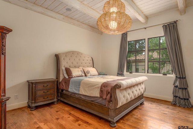 bedroom featuring beamed ceiling, wood-type flooring, and wood ceiling