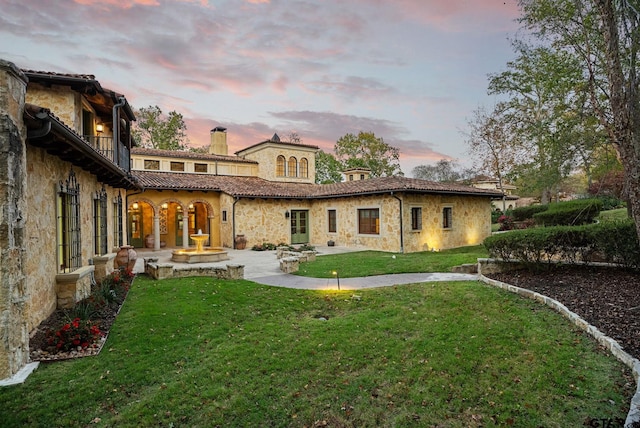 back house at dusk with a yard