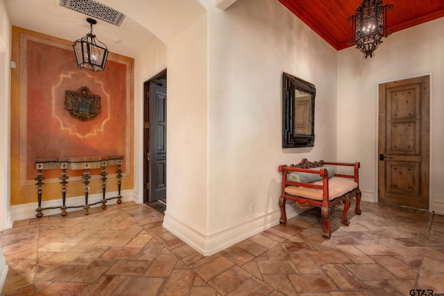 4573 Cascades Shoreline Dr, Tyler, TX 75709 - hall with stone tile floors, wood ceiling, arched walkways, baseboards, and a chandelier