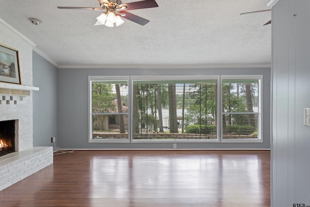 unfurnished living room featuring crown molding, a fireplace, a textured ceiling, a ceiling fan, and wood finished floors