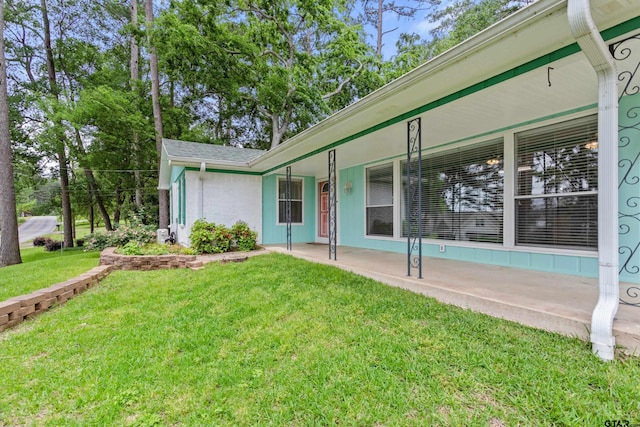 exterior space with a porch and a front yard