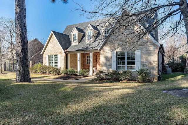 new england style home featuring stone siding, central AC, and a front lawn