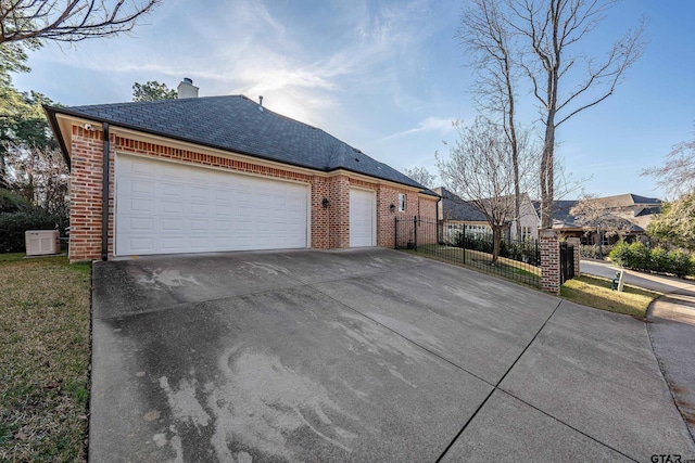 view of front of house with an attached garage, brick siding, fence, concrete driveway, and a chimney