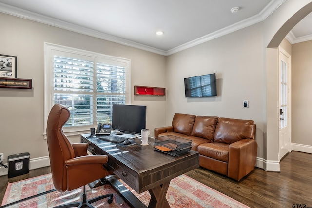 office space with arched walkways, crown molding, baseboards, and wood finished floors