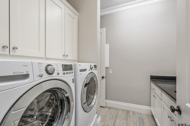 laundry room with light wood-style flooring, baseboards, washer and dryer, ornamental molding, and cabinet space