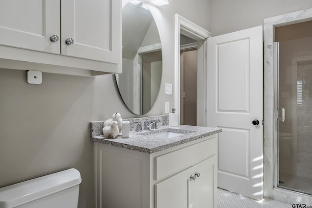 bathroom featuring a shower stall, toilet, and vanity