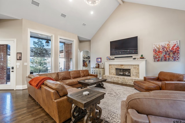 living room featuring visible vents, dark wood-type flooring, beamed ceiling, a fireplace, and high vaulted ceiling