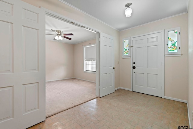 foyer entrance with ceiling fan and ornamental molding