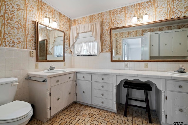 bathroom featuring toilet, vanity, and tile walls