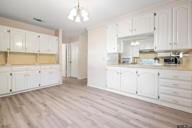 kitchen with white cabinets, a chandelier, pendant lighting, and light wood-type flooring