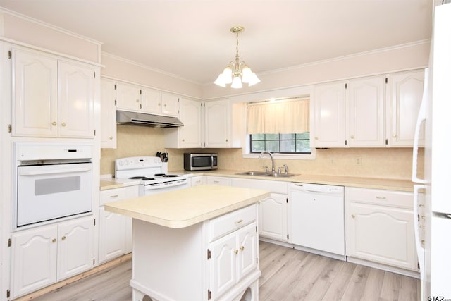 kitchen featuring a center island, white cabinetry, sink, white appliances, and light hardwood / wood-style flooring