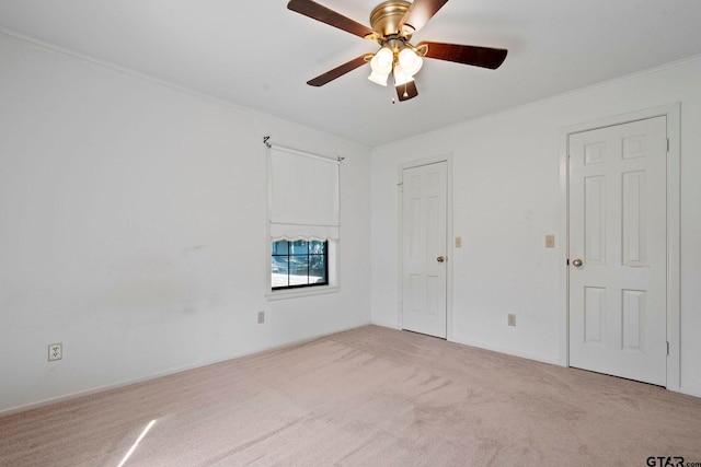 carpeted empty room featuring ornamental molding and ceiling fan