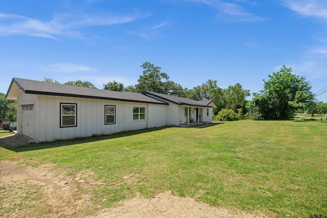 1325 Fm 23 W, Rusk, TX 75785 - back of house featuring board and batten siding, a lawn, and an attached garage