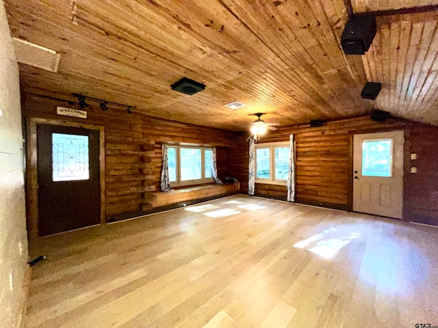 interior space featuring lofted ceiling, hardwood / wood-style flooring, wooden ceiling, and rustic walls