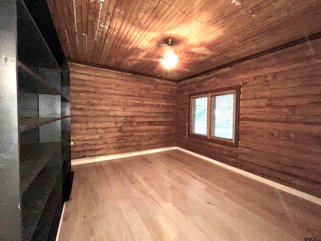 empty room featuring hardwood / wood-style flooring, wooden ceiling, and wooden walls