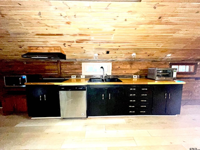 kitchen featuring dishwasher, sink, and wooden walls