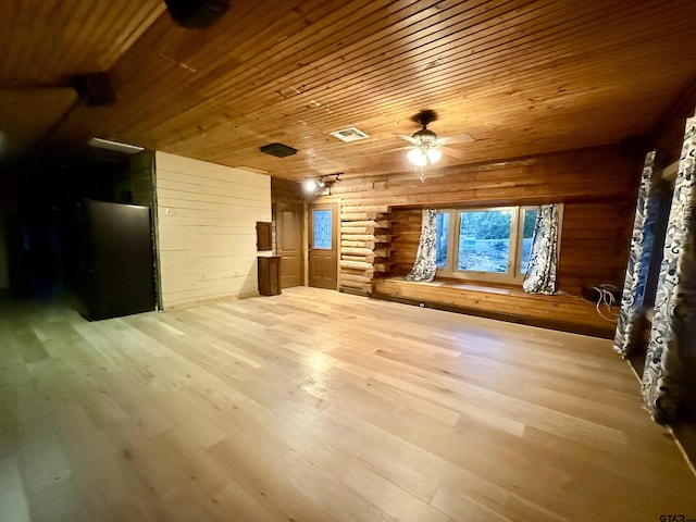 unfurnished living room with wood walls, rustic walls, wooden ceiling, and light hardwood / wood-style flooring