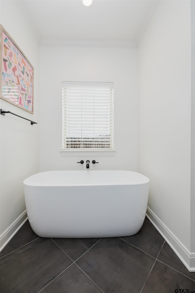 full bath with tile patterned flooring, crown molding, and a freestanding tub