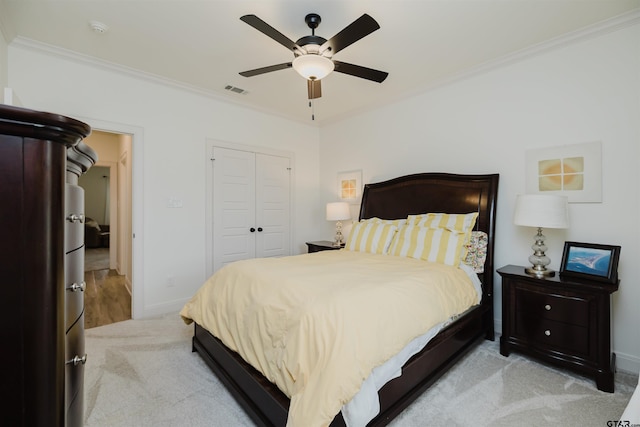 bedroom with baseboards, light colored carpet, a closet, and ornamental molding