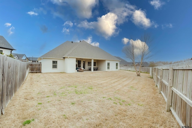 back of house with a fenced backyard and a patio area