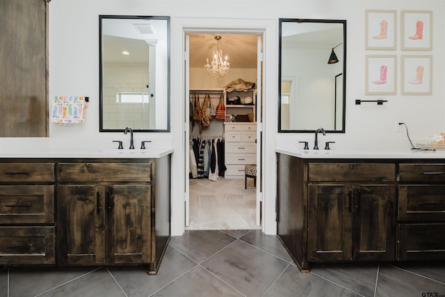 bathroom featuring a spacious closet, a sink, tile patterned flooring, and two vanities