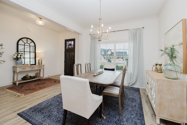 dining space with light wood-style flooring, baseboards, an inviting chandelier, and ornamental molding