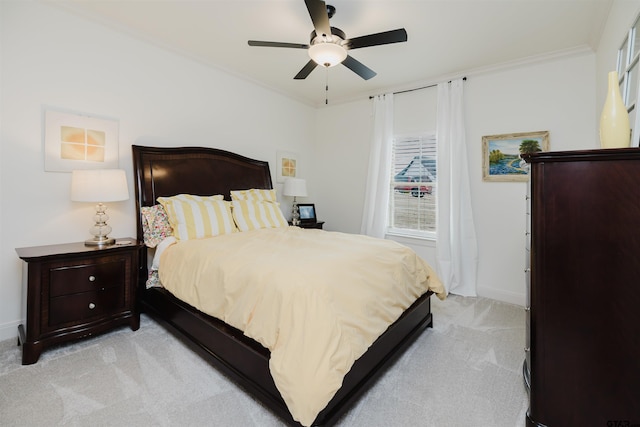 bedroom with light carpet, ceiling fan, baseboards, and ornamental molding