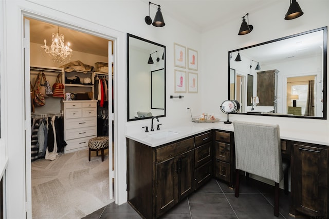 bathroom featuring a spacious closet, tile patterned flooring, vanity, and an inviting chandelier