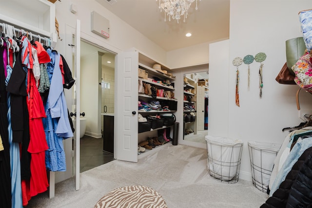 spacious closet with a notable chandelier and carpet floors